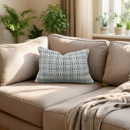 Beige sofa with a textured blue pillow in a cozy living room setting.