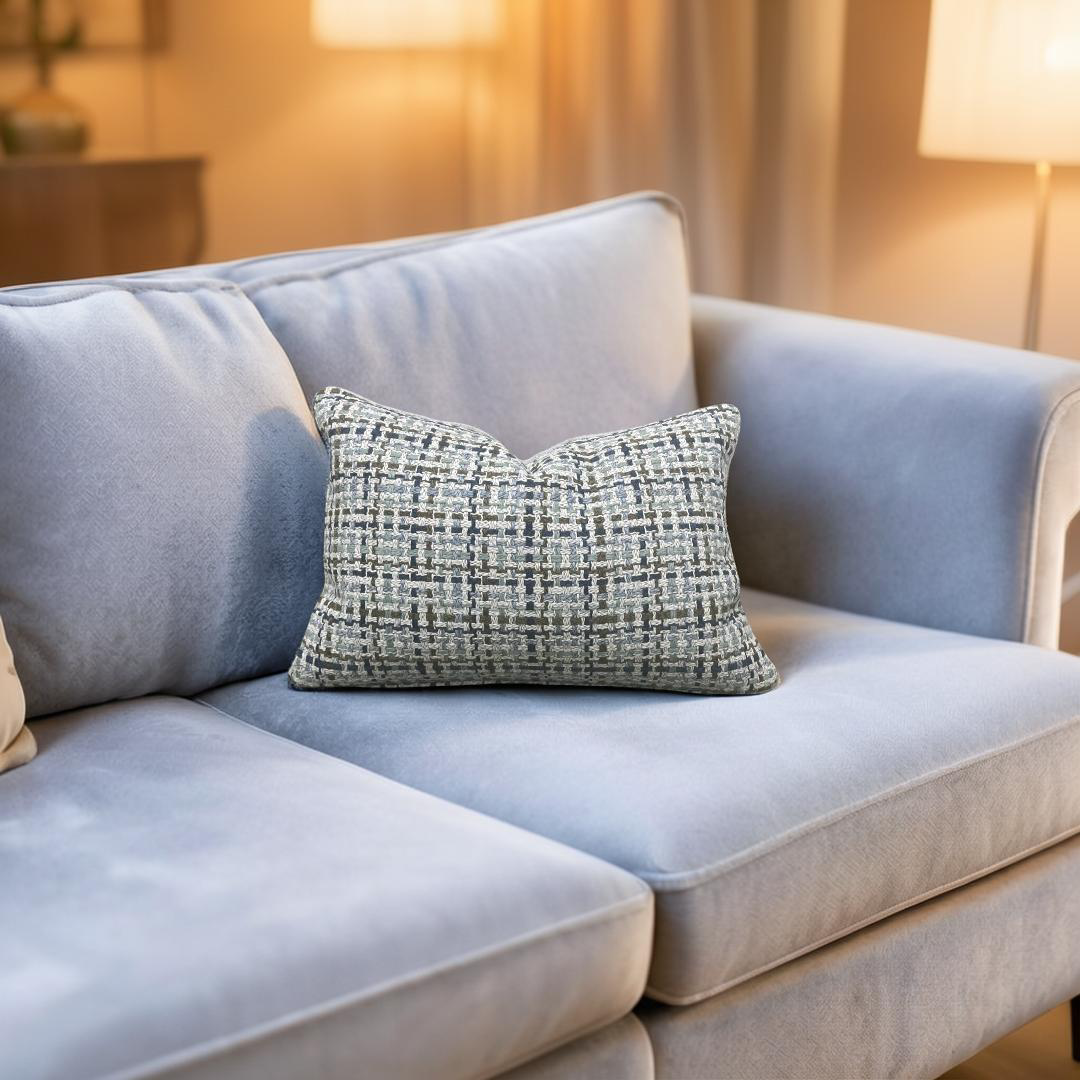 Light blue sofa with a patterned pillow in a softly lit room
