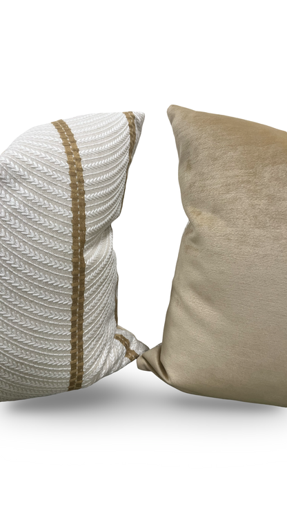 Two textured pillows, one white with brown stripes and the other beige, on a light gray background.