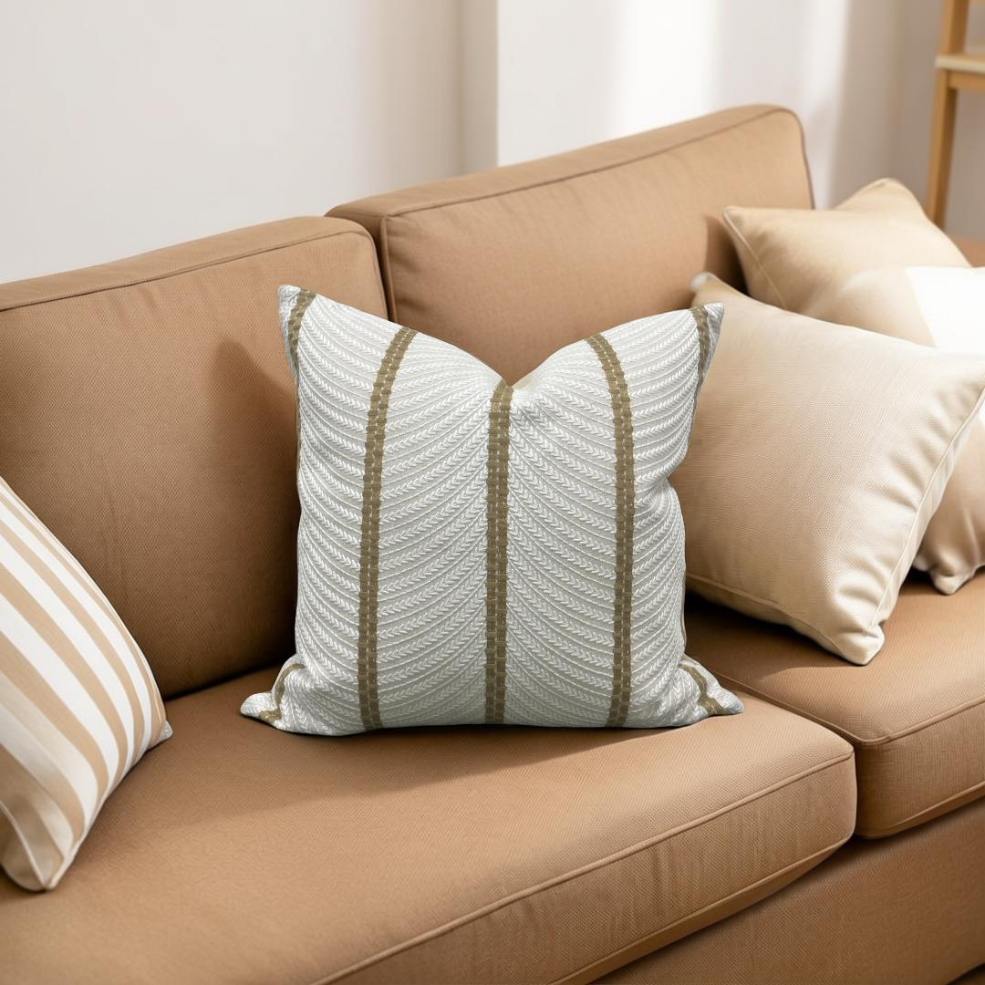 Beige sofa with decorative pillows including a striped pillow on a neutral background
