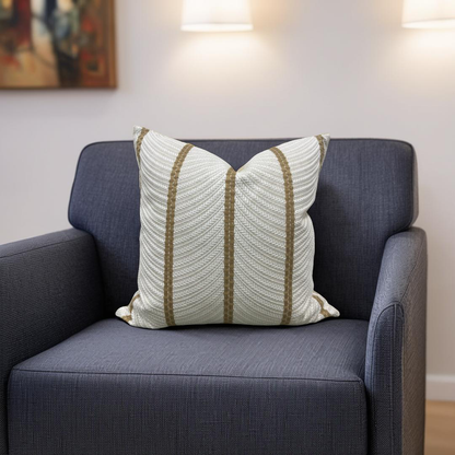 Decorative pillow with striped pattern on a gray sofa in a living room setting.