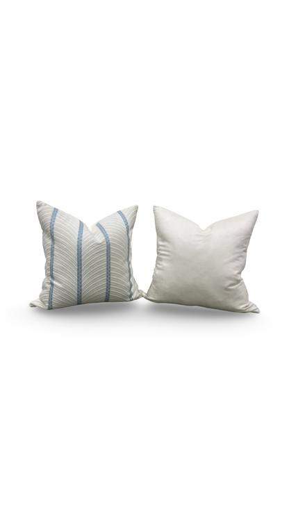 Two pillows, one with blue stripes and one plain white, on a white background