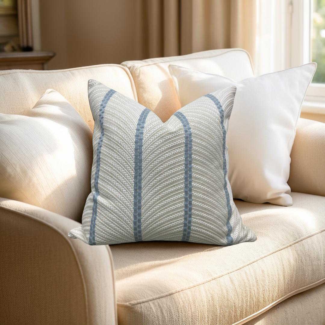 Decorative pillow with blue stripes on a beige sofa