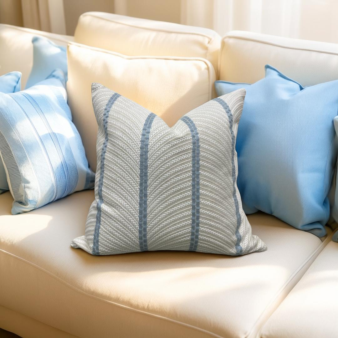 Decorative pillows with blue and gray patterns on a beige sofa.