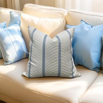 Decorative pillows with blue and gray patterns on a beige sofa.