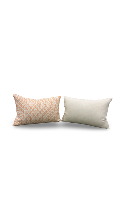 Two pillows, one beige with a subtle pattern and one white, on a white background