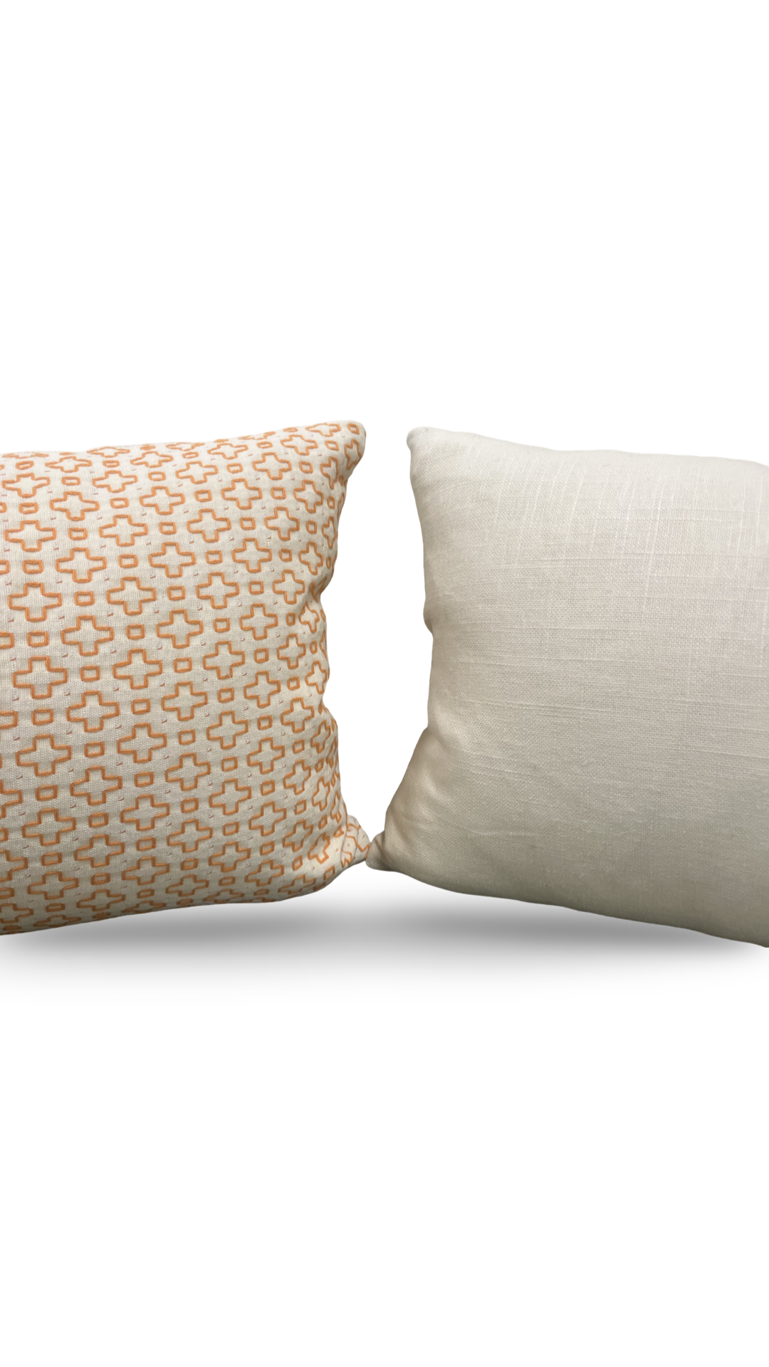 Two pillows, one with a geometric pattern and one plain, on a white background
