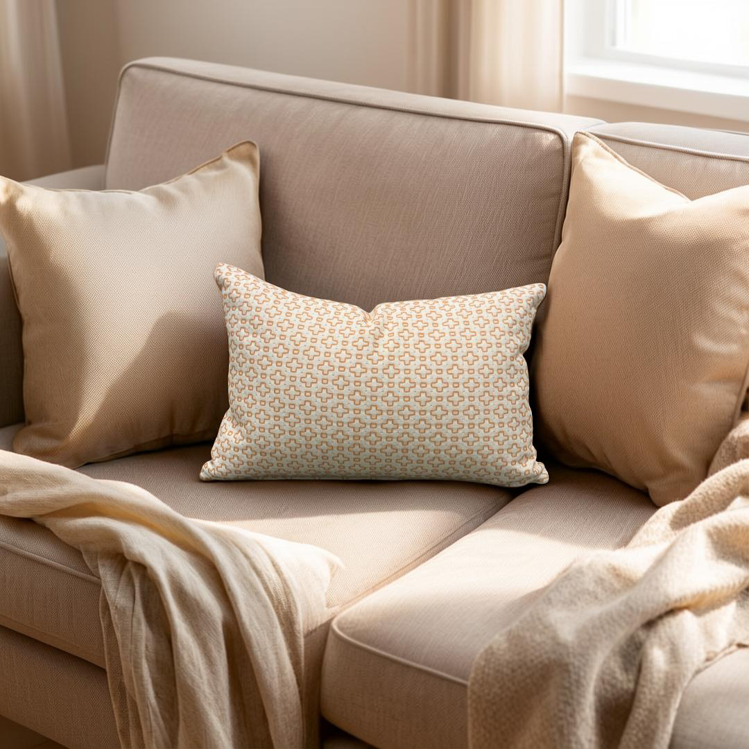 Beige sofa with patterned pillow and blanket in a cozy living room setting