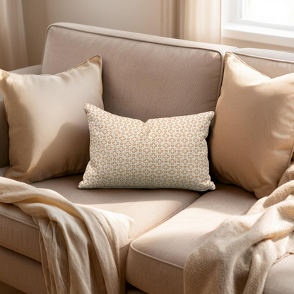Beige sofa with patterned pillow and blanket in a cozy living room setting