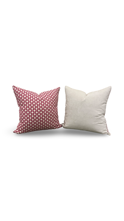 Two pillows, one with a pink polka dot pattern and the other plain white, on a white background.