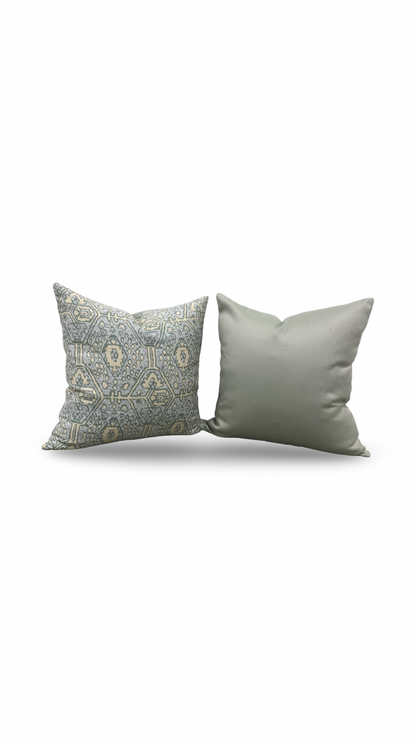 Two decorative pillows, one with a patterned design and the other plain, on a white background.