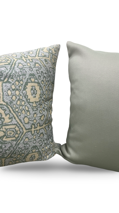 Two pillows, one with a geometric pattern and the other plain, on a white background