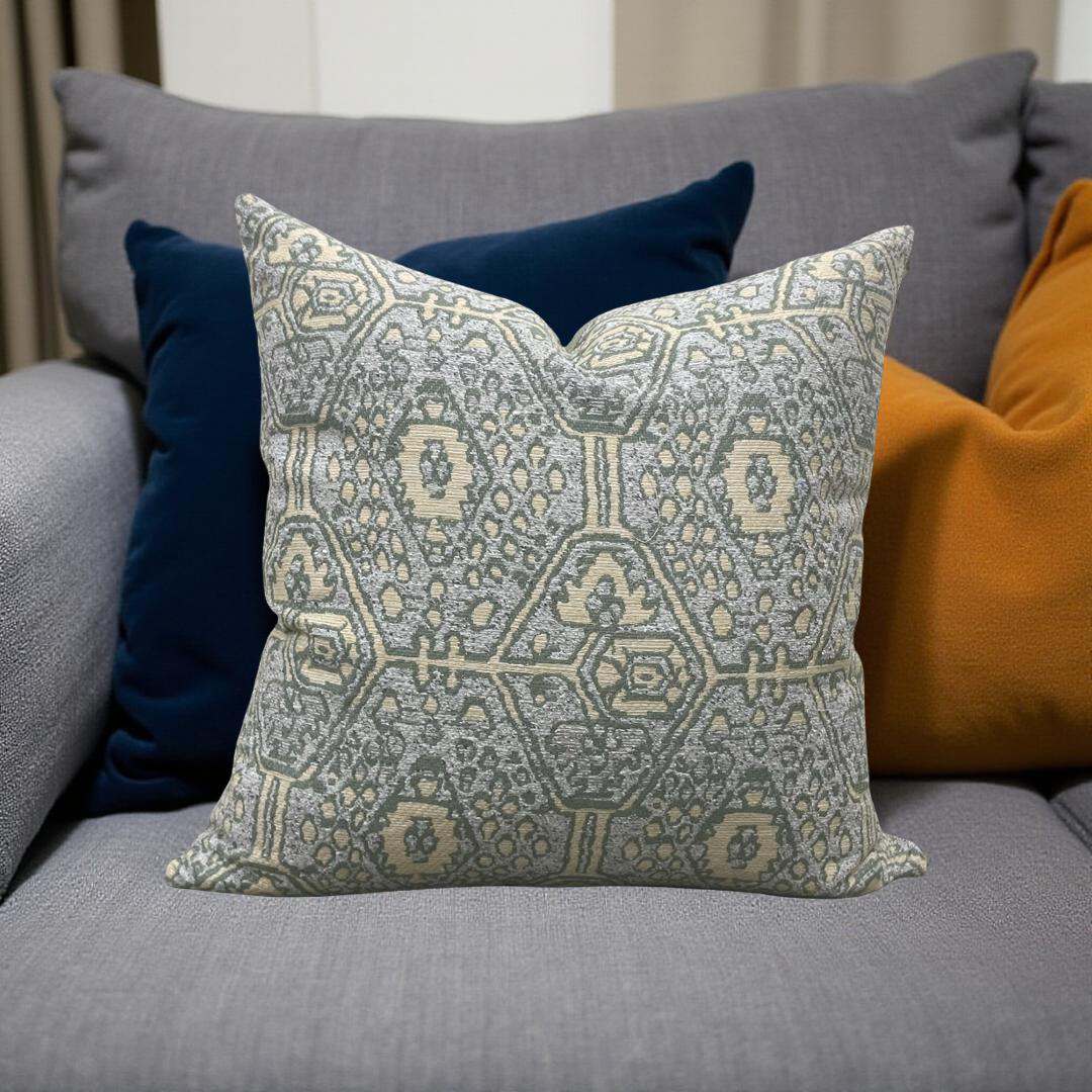 Decorative pillow with geometric pattern on a gray sofa with other pillows.